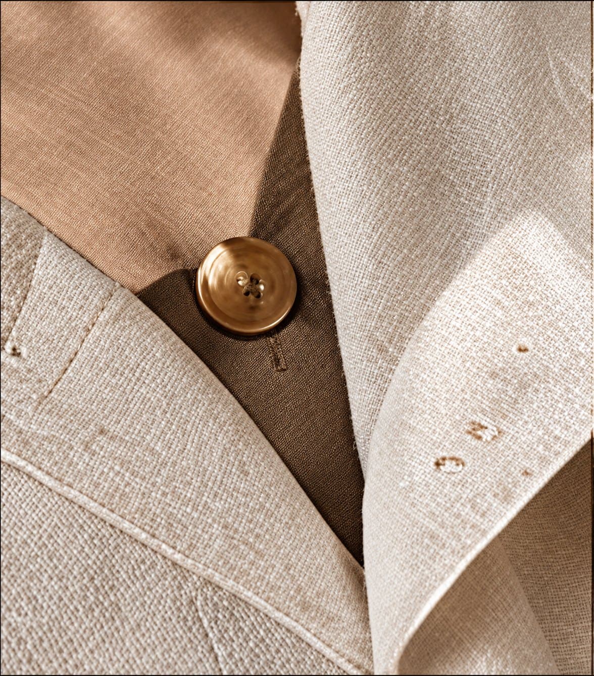 Detalhe de botão dourado em peça de linho